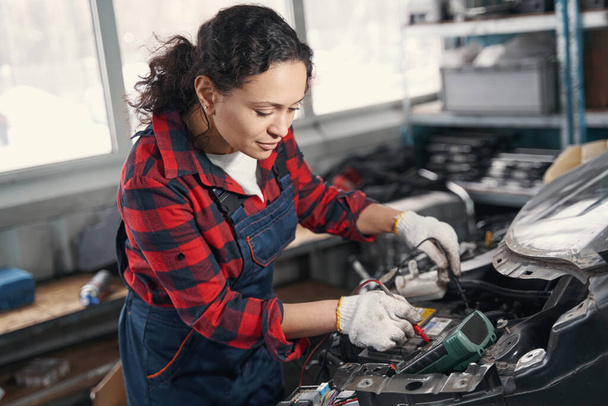 Pleased female mechanic fixing engine of auto - Fotografie, Obrázek