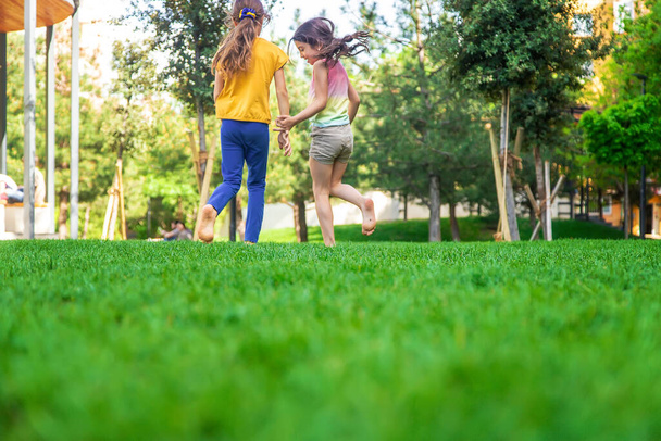 Детские ноги ходят по траве. Выборочный фокус. Люди. - Фото, изображение
