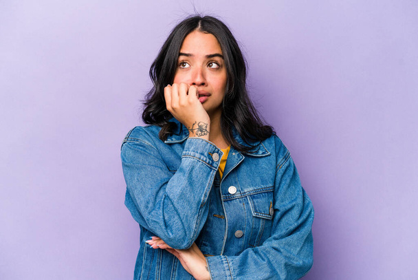 Young hispanic woman isolated on purple background biting fingernails, nervous and very anxious. - Photo, Image