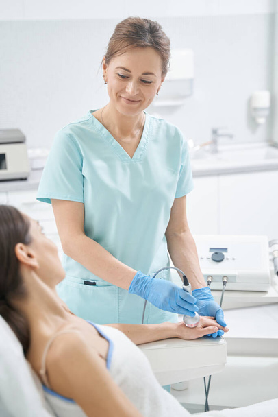 Woman receiving cosmetology treatment in beauty salon - Foto, imagen