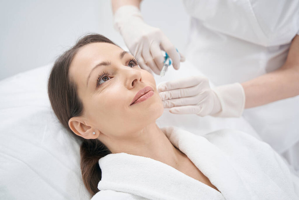 Kobieta otrzymująca wstrzyknięcie liftingu twarzy w klinice kosmetycznej - Zdjęcie, obraz