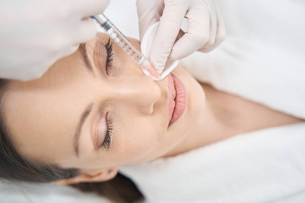 Doctor beautician doing beauty injection in woman lips - Foto, immagini