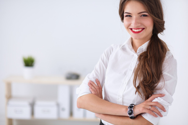 Attractive businesswoman with her arms crossed  standing in office - Fotoğraf, Görsel
