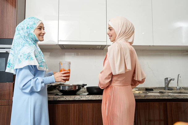 Muslimische Frauen kochen und lächeln in der Küche - Foto, Bild