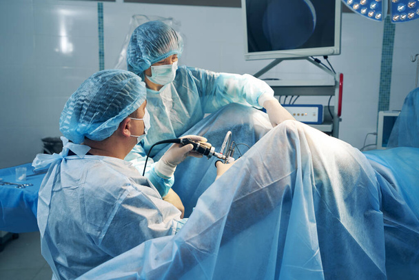 Cirujanos usando laparoscopio durante operación en área pélvica - Foto, imagen