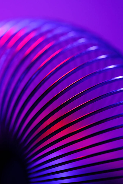 Kelattu metalli keväällä lähikuva riittävän lujat ja joustavat ominaisuudet neon valossa - Valokuva, kuva