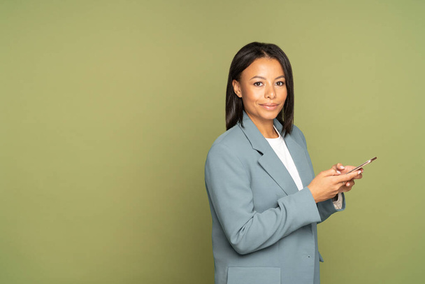 Confident african businesswoman with smartphone. Millennial female entrepreneur holding mobile phone - Photo, Image