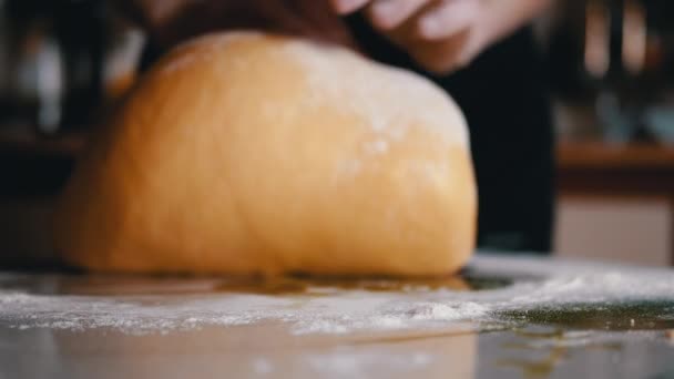 Samičí ruce Knedlíkové těsto na kuchyňském stole posypané moukou. Volné, žluté, hladké těsto na pečení chleba, buchty. Vařím sladké lahodné pečivo pro rodinu. Zpomal. Detailní záběr. - Záběry, video