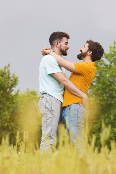 若いゲイの男性のカップル,公園で受け入れます - 写真・画像