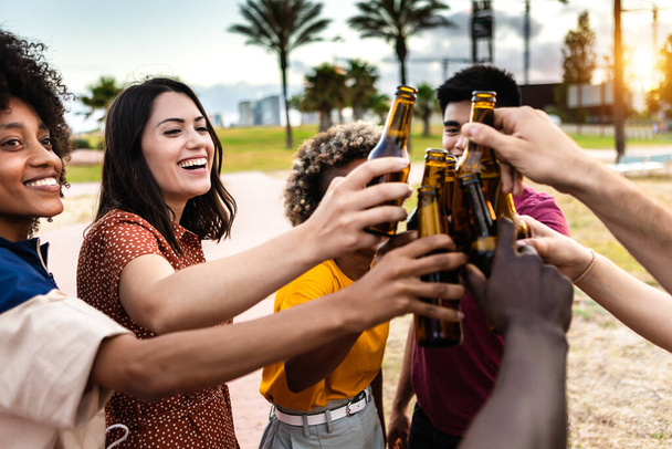 Grupo de diversos amigos jóvenes que beben cerveza y se divierten juntos en verano - Foto, Imagen