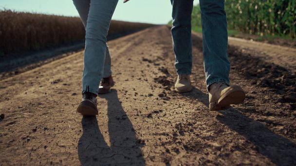 Boeren schoenen lopen grond weg close-up. Landbouwers inspecteren veeteelt - Foto, afbeelding