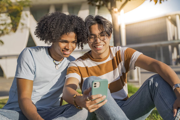 Multicultural teenagers friends laughing selfie cellphone diversity in the modern city street. - 写真・画像