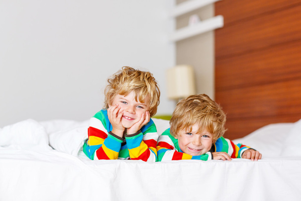 Twee kleine broer of zus kind jongens plezier in bed na het slapen  - Foto, afbeelding