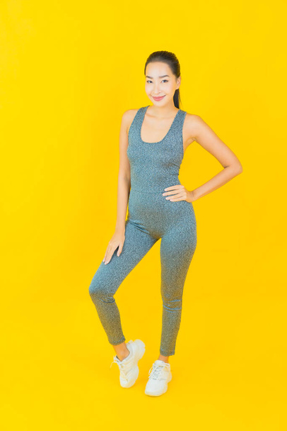 Retrato bela jovem mulher asiática com sportswear pronto para o exercício no fundo amarelo - Foto, Imagem