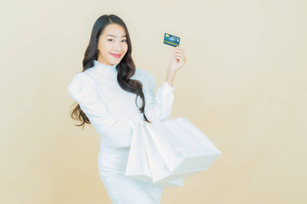 Retrato hermosa joven mujer asiática sonrisa con bolsa de compras en el fondo de color - Foto, Imagen