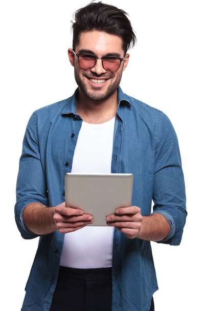 hombre sonriendo mientras sostiene una tableta de computadora
 - Foto, imagen