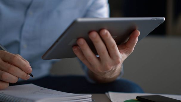 Empresario hombre usando tableta escritura cuaderno información investigación en el lugar de trabajo - Foto, Imagen
