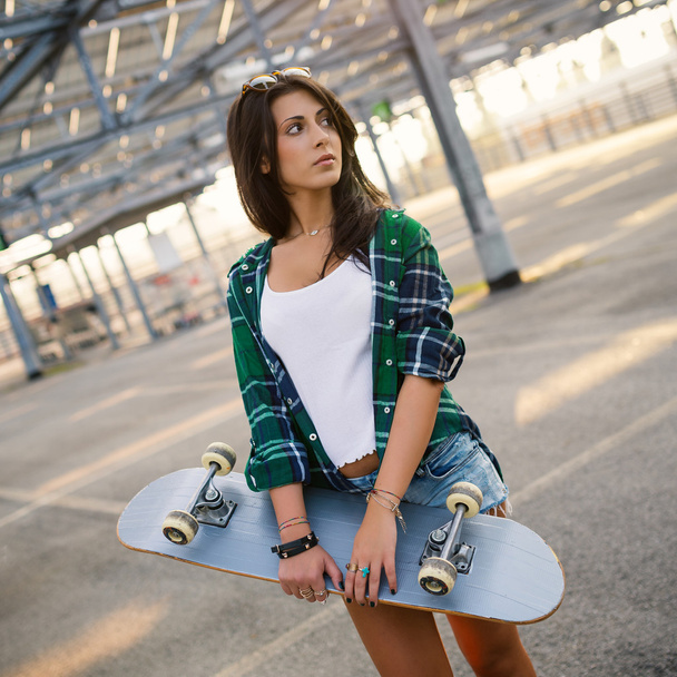 Teenager with skateboard portrait outdoors - Fotó, kép