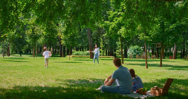 Father watching badminton game with gaughter on picnic. Active family rest. - Zdjęcie, obraz