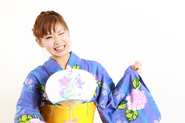 Young woman wearing Japanese kimono,suffers from intense heat - Foto, imagen