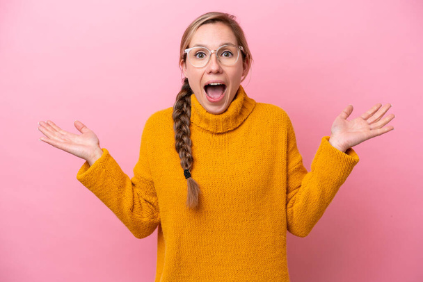 Young caucasian woman isolated on pink background with shocked facial expression - Foto, Bild