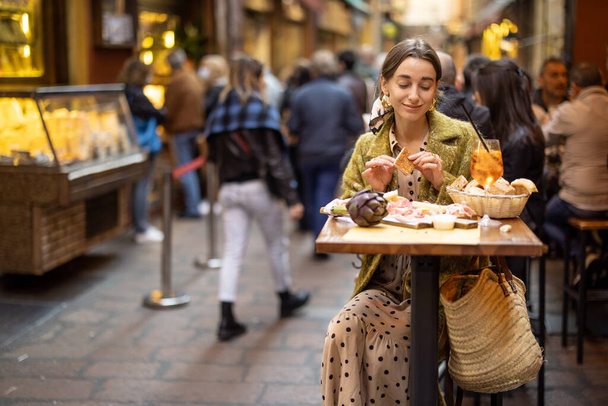 Nainen Italian välipaloja ja juoda baarissa ulkona - Valokuva, kuva