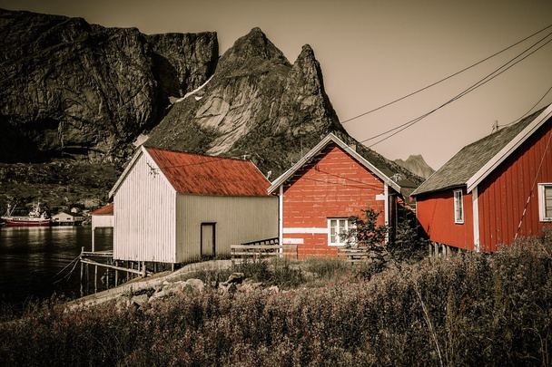 Perinteiset puutalot vastaan vuoren huippu Reine kylässä, Norja
 - Valokuva, kuva