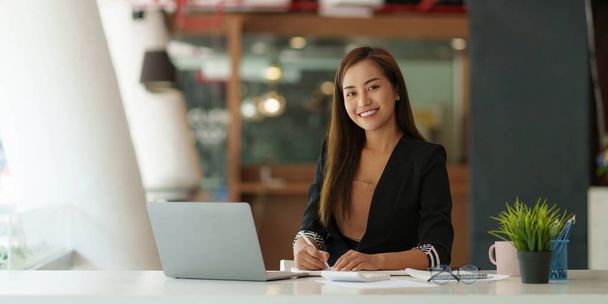 Portrét šťastné asijské podnikatelky, usmívající se a pracující v kanceláři. - Fotografie, Obrázek