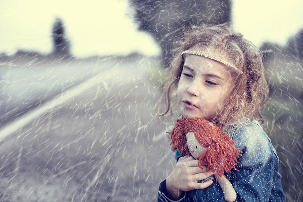 Orphan in the winter snowy day sitting alone outdoors - Φωτογραφία, εικόνα