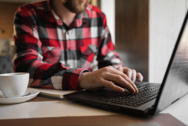 Close-up of businessman wpisując na laptopie, ręcznie wpisując wiadomość na laptopie klawiatury czat znajomego wyszukiwania informacji z Internetu podczas pracy na komputerze. Młodzi ludzie pracują na urządzeniach mobilnych. - Zdjęcie, obraz
