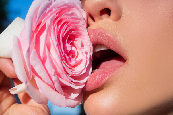 Lips with lipstick closeup. Pink beauty. Mouth icon. Rose lip, young pink rose, lip balm, tender fashionable lipstick. Beautiful woman lips with rose. - Foto, Imagem
