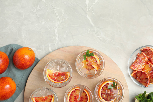 Delicious refreshing drink with sicilian orange on light grey marble table, flat lay. Space for text - Φωτογραφία, εικόνα
