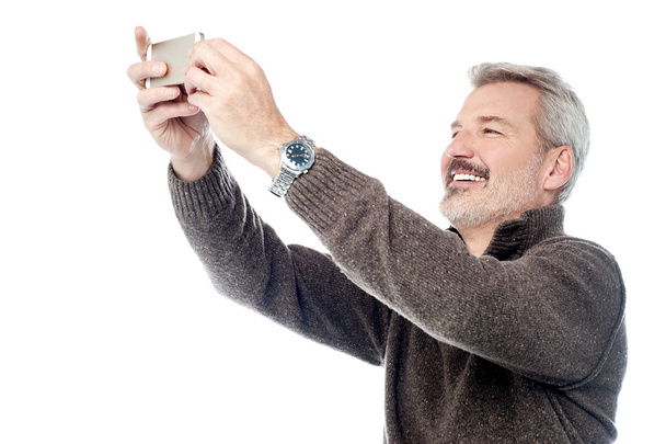 Mature man taking selfie - Фото, изображение