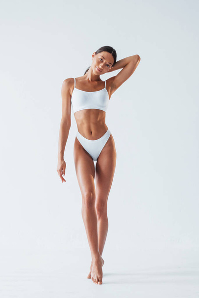 Beautiful woman with slim body in underwear is in the studio. - Photo, image
