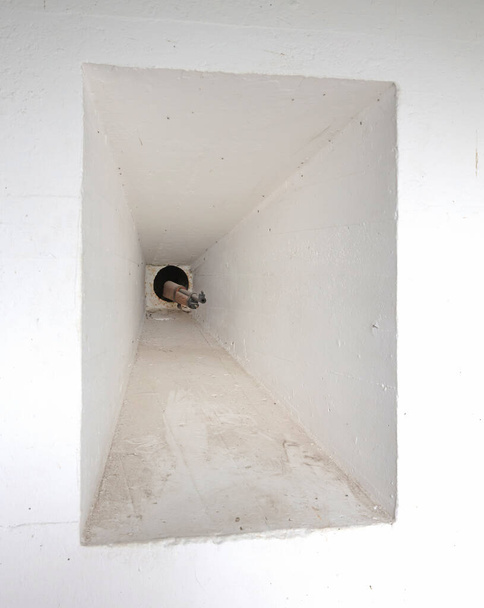 Pequeno buraco com uma arma saindo dele na entrada de um antigo bunker WW2, foco seletivo - Foto, Imagem