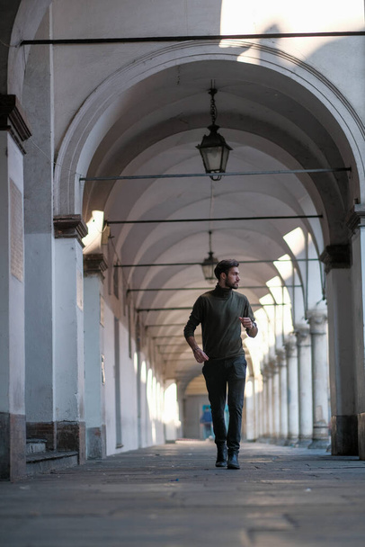 bello ragazzo italiano passeggia sotto i portici di Parma. Foto di alta qualità - Foto, immagini