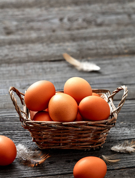 Свіжі курячі яйця в кошику на сільському тлі
 - Фото, зображення