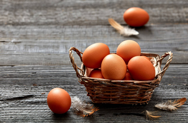 Świeże jaja kurze w koszyku na rustykalnym tle - Zdjęcie, obraz