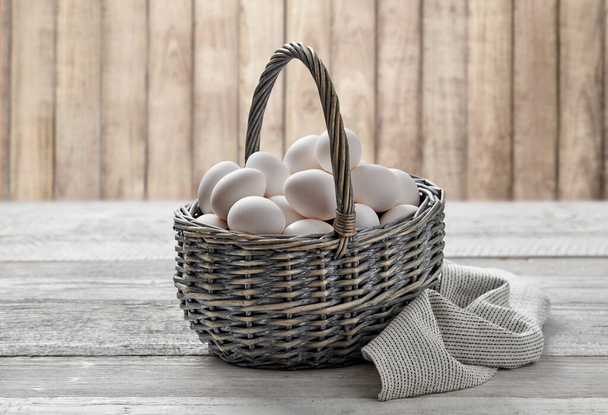 Basket with white farm eggs on wooden background - Fotoğraf, Görsel