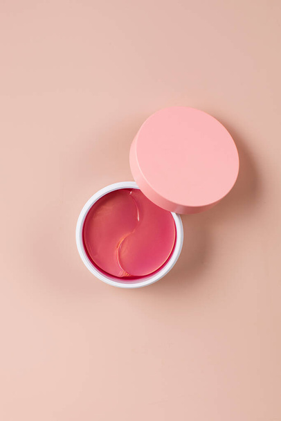 Pink hydrogel patches for youthful skin around the eyes in a plastic box with space for your brand on a pink background. - Φωτογραφία, εικόνα