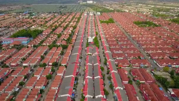 住宅や不動産のための人口過密都市の高密度の村に囲まれた郊外地域の空中ドローンショット - 映像、動画