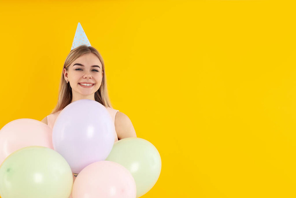 Konzept der Happy Birthday mit attraktiven Mädchen auf gelbem Hintergrund - Foto, Bild