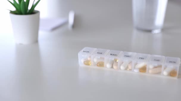Boîte à pilules médicale avec des doses de comprimés pour prendre quotidiennement des médicaments avec des médicaments, des capsules - Séquence, vidéo