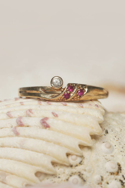 Ring product shot. Golden ring on marine shell background. Jewelry fashion photography. - Photo, Image