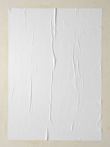 Blank white wheatpaste glued paper poster mockup on white wall background - Foto, afbeelding
