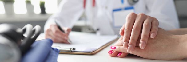 Жінка-лікар тримає руку пацієнтки, крупним планом
 - Фото, зображення