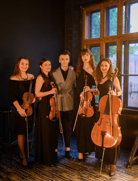 Direttore d'orchestra con giovani violinisti e violoncellisti  - Foto, immagini