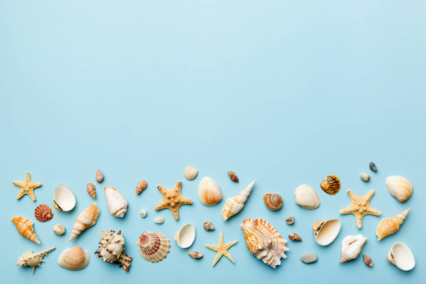 Summer time concept Flat lay composition with beautiful starfish and sea shells on colored table, top view with copy space for text. - Valokuva, kuva