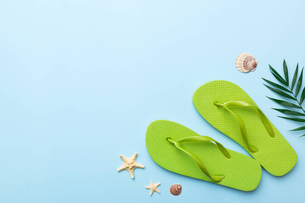 Flat lay composition with flip flops and seashell on colored background. Space for text top view. - Foto, imagen