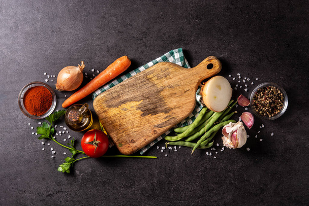 Assortiment van groenten, kruiden en specerijen op zwarte achtergrond. Bovenaanzicht. Kopieerruimte - Foto, afbeelding